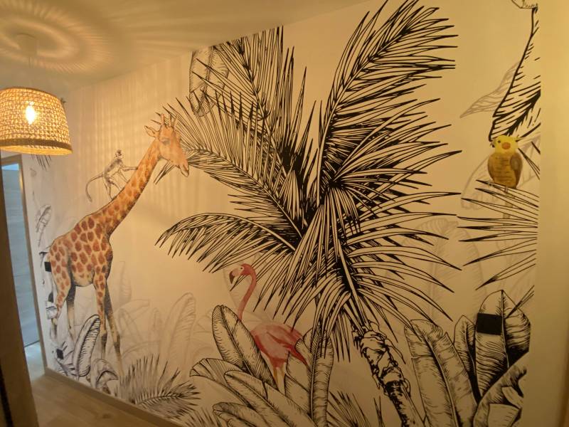 Pose de papier peint grand format sur le mur du couloir dans une maison neuve à Frouzins proche Saint-Lys motif jungle animaux paysage